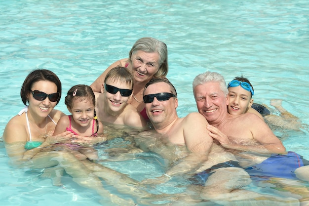 Retrato de una familia feliz divirtiéndose en la piscina