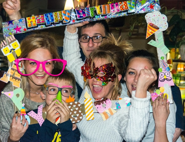 Foto retrato de una familia feliz con gafas de novedad y decoración durante la celebración del cumpleaños
