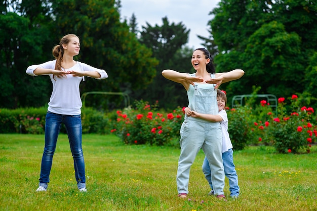 Retrato de familia feliz haciendo ejercicio físico o fitness en el parque