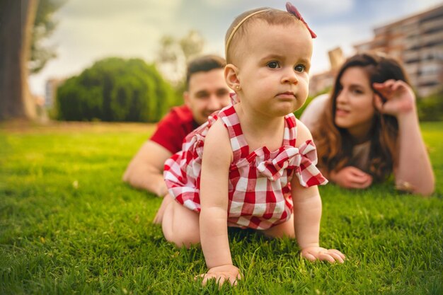 Retrato de familia feliz joven tumbado en la hierba en un dia soleado foto de alta calidad