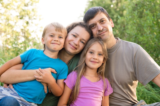 Foto retrato de una familia feliz, madre y padre, hijo e hija, en la naturaleza al aire libre en verano