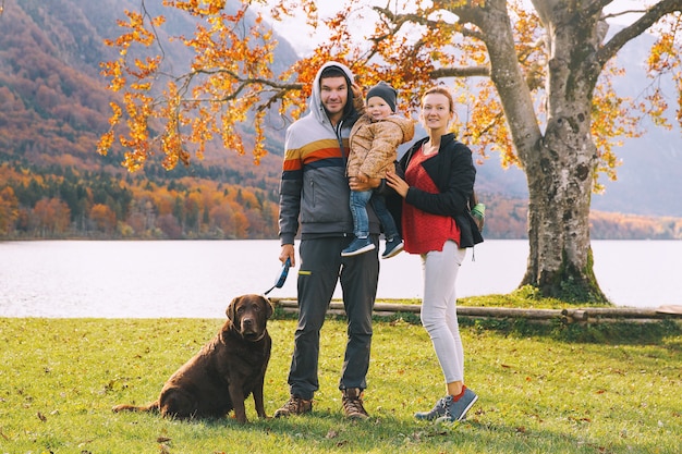 Retrato de familia feliz, madre, padre, niño y perro al aire libre Otoño en el lago Bohinj, Eslovenia