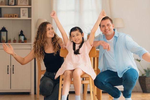 Retrato de familia feliz con una niña sonriendo mirando los sincronismos de la cámara