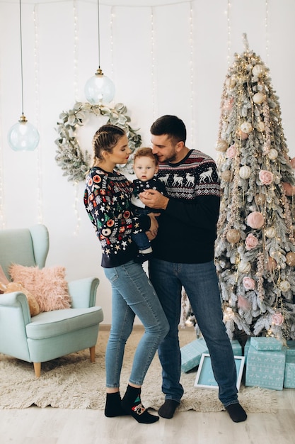 Retrato de familia feliz de padre, madre y pequeño hijo rizado celebrando la Navidad juntos en casa Concepto de Nochevieja