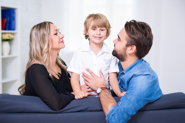 Retrato de familia feliz - pareja joven e hijo pequeño en casa