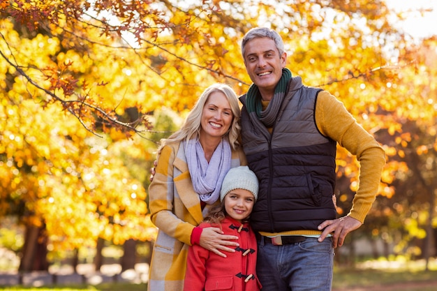 Retrato de familia feliz en el parque durante el otoño