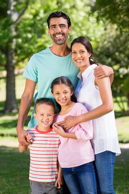 Foto retrato de familia feliz de pie en el parque