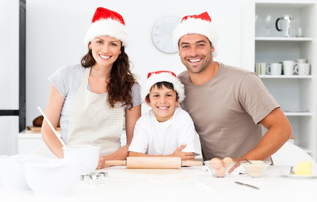 Retrato de una familia feliz preparando galletas de Navidad