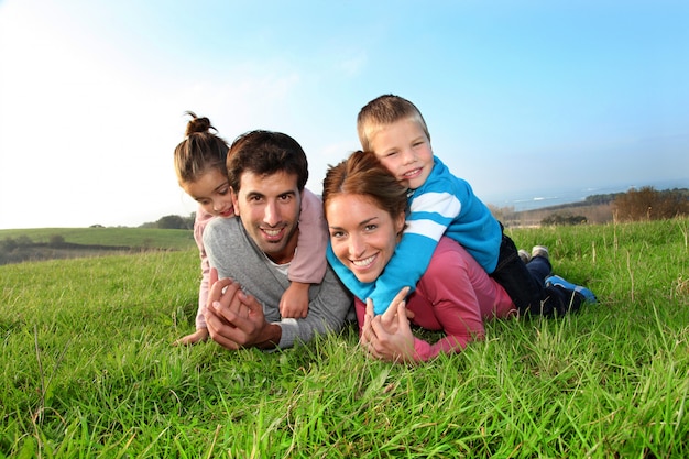 Retrato de la familia feliz que pone en campo del país