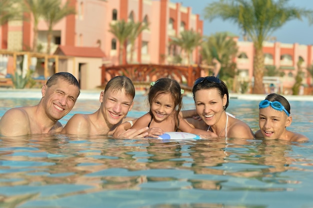 Retrato de una familia feliz relajarse en la piscina