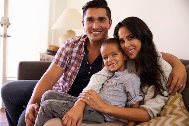 Foto retrato de familia feliz sentada en un sofá en casa