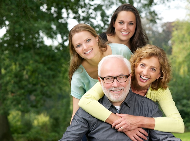 Foto retrato de una familia feliz sonriendo y divirtiéndose al aire libre