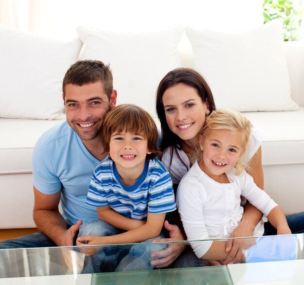 Retrato de familia feliz sonriendo en la sala de estar