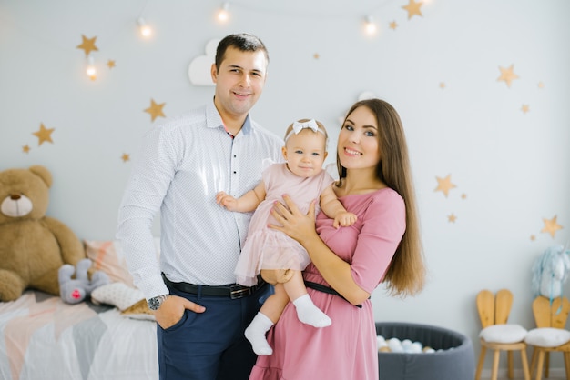 Retrato de una familia feliz y sonriente con una pequeña hija en sus brazos