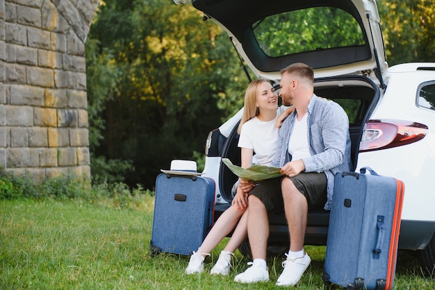 Retrato de familia feliz. Vacaciones, viajes: la familia está lista para viajar durante las vacaciones de verano. ruta de maletas y coche.