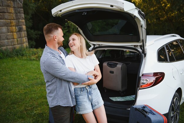 Retrato de familia feliz. Vacaciones, viajes: la familia está lista para viajar durante las vacaciones de verano. ruta de maletas y coche.