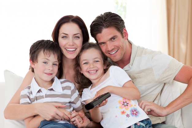 Retrato de una familia feliz viendo televisión