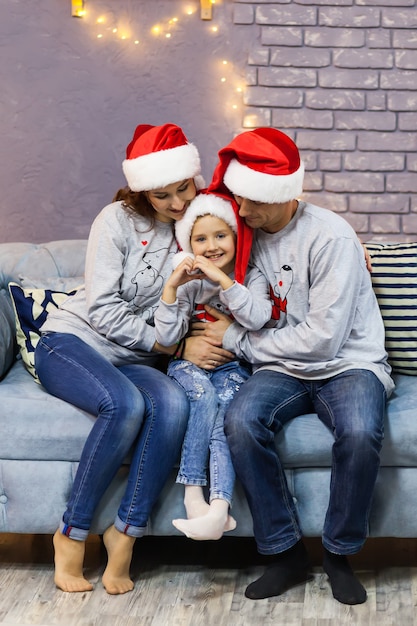 Retrato de familia en gorros rojos de Santa