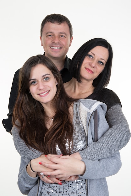 Retrato de familia joven feliz con hija - en la pared blanca