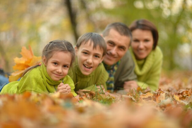 Retrato de familia joven feliz en el parque otoño