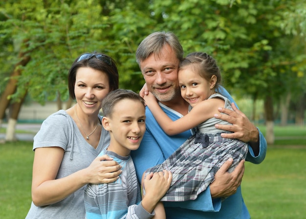 Foto retrato de familia joven feliz en el parque