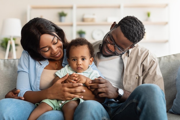 Retrato de familia negra feliz sonriendo mirando al niño