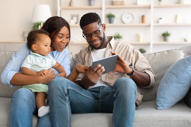 Retrato de familia negra usando tableta digital en casa