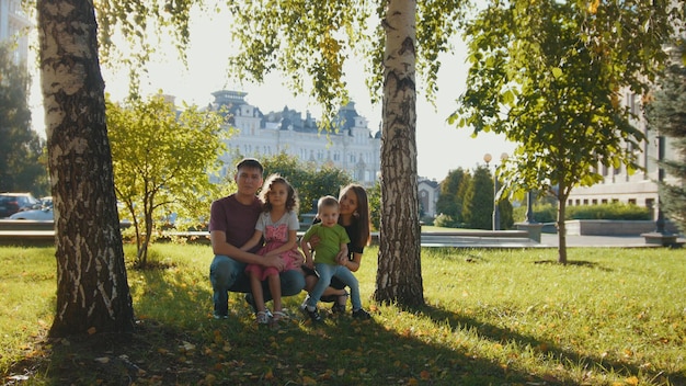 Retrato de familia en el parque de verano al atardecer -Padre, madre e hijos juntos