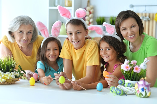 Retrato de familia pintando huevos de Pascua tradicionales en diferentes colores en casa