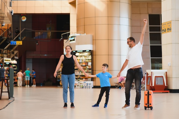 Retrato de familia que viaja con maletas en el aeropuerto