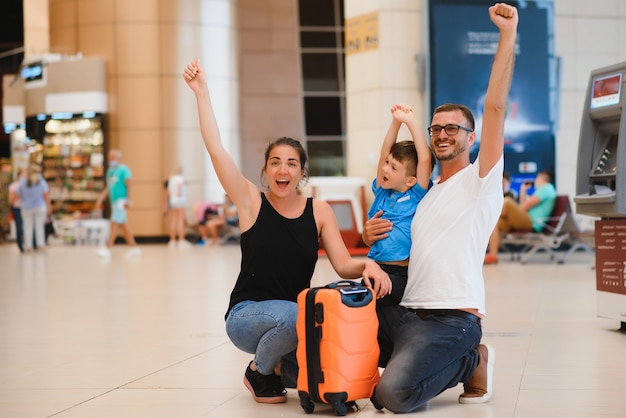 Foto retrato de familia que viaja con maletas en el aeropuerto