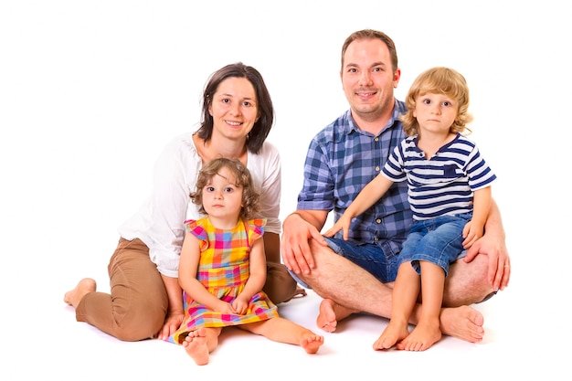 Foto retrato de una familia sentada contra un fondo blanco