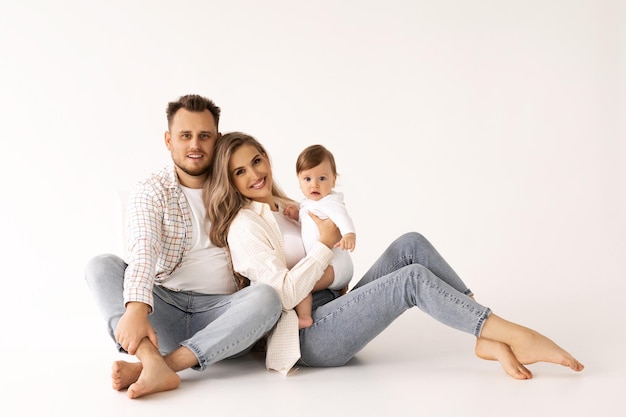 Foto retrato de familia sobre un fondo blanco, retrato de concepto de familia feliz. los padres juegan con el chil