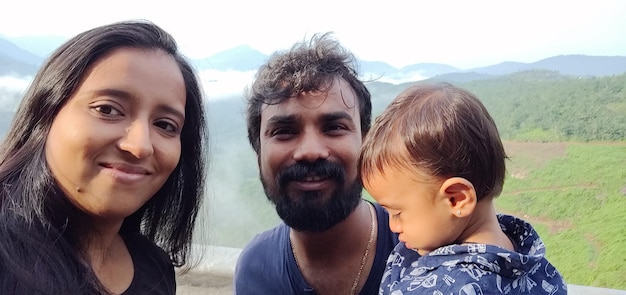 Foto retrato de una familia sonriente contra la montaña