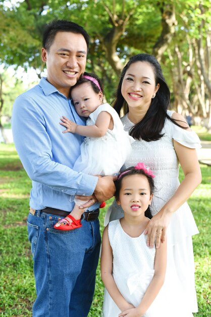 Retrato de una familia sonriente de pie en el parque