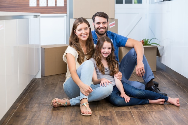 Retrato de familia sonriente sentada en el piso