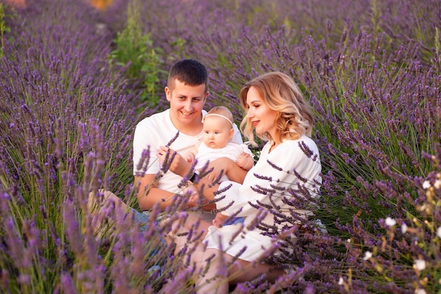 Foto retrato familiar madre padre y bebé en el campo de lavanda divirtiéndose juntos. pareja feliz, con, chil