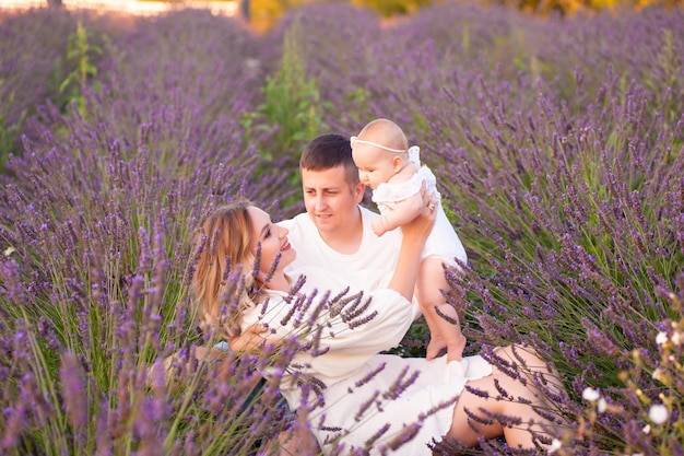 Retrato familiar madre padre y bebé en el campo de lavanda divirtiéndose juntos. pareja feliz, con, chil