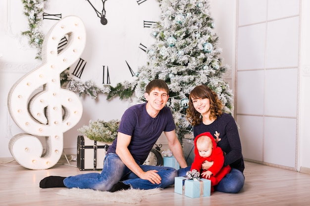 Retrato familiar de Navidad en la sala de estar de vacaciones en el hogar, decoración de la casa por el árbol de Navidad