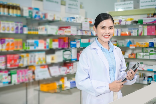 Foto retrato de una farmacéutica que usa una tableta en una farmacia moderna