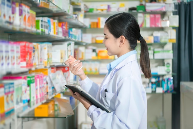Retrato de una farmacéutica que usa una tableta en una farmacia moderna