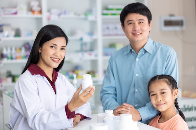 Retrato de farmacéutico y paciente mira cámara y sonriendo en farmacia