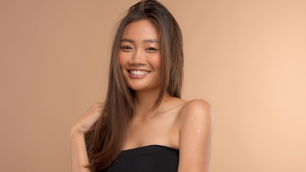 Retrato fechado do modelo japonês asiático tailandês com cabelo coberto seu rosto feliz, sorridente, maquiagem neutra, cabelo saudável