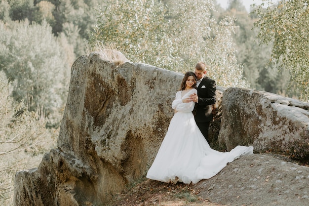 Retrato de felices recién casados abrazándose, sonriendo y mirándose. Concepto de pareja de novios