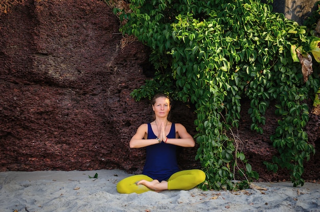 Retrato de felicidad joven practicando yoga al aire libre