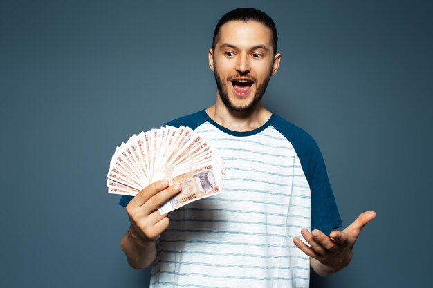 Retrato de felicidad joven sosteniendo dinero leu moldavo billetes en azul