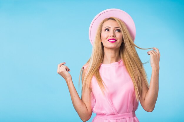 Retrato de feliz alegre sonriente joven hermosa mujer rubia en pared azul