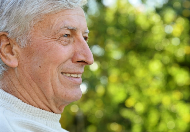 Retrato de feliz anciano en el parque de verano