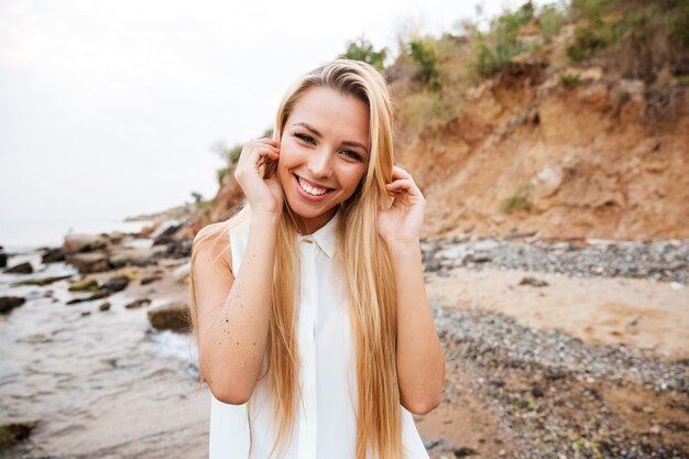 Retrato, de, feliz, atractivo, mujer joven, posición, en la playa