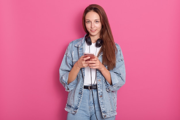 Retrato de feliz bella joven usando su teléfono